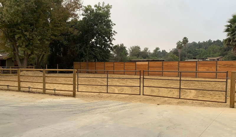 new railed fence and solid wood fence with metal gate